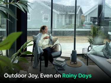 Woman under blanket, reading and enjoying a hot beverage under glass pergola on a rainy day. Text says "Outdoor Joy, Even on Rainy Days