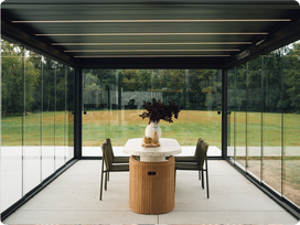 Modern outdoor dining area with a glass-walled PERGOLUX pergola, table, and chairs.