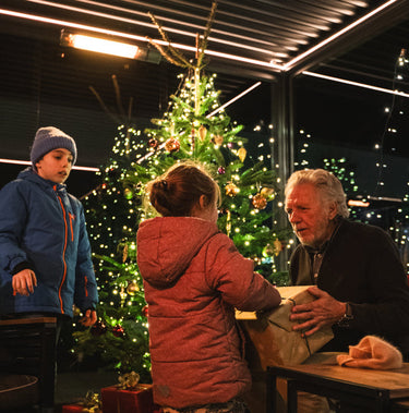 Family gathered around a Christmas tree with lights in the background