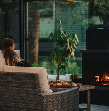 Couple sitting on a patio with a fire pit and outdoor furniture.